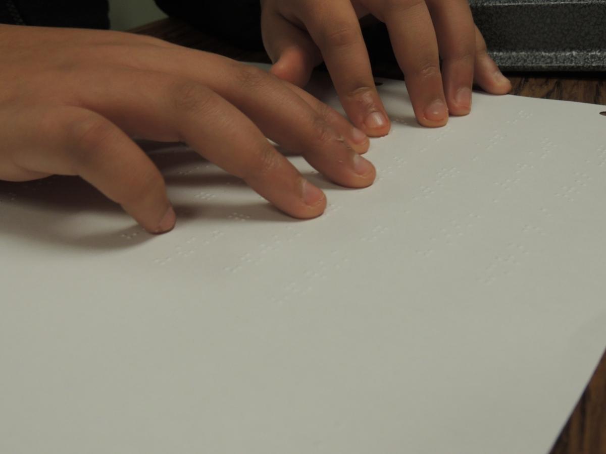 hands reading braille