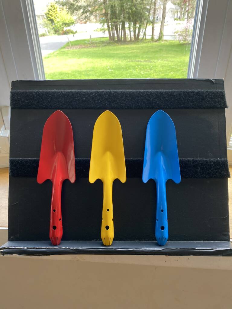 Three hand shovels in solid red, yellow, and blue