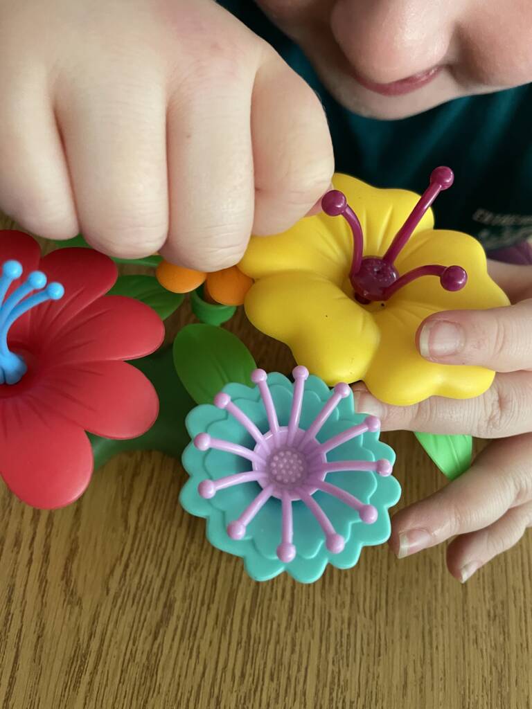 Student exploring the plastic model flowers.