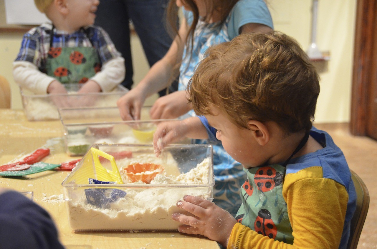 Students using individual sandboxes at a table for sensory play.