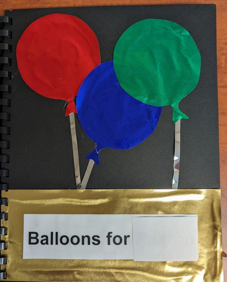 A page in the balloon book with 3 circular balloons an the sentence says, Balloons for "name".