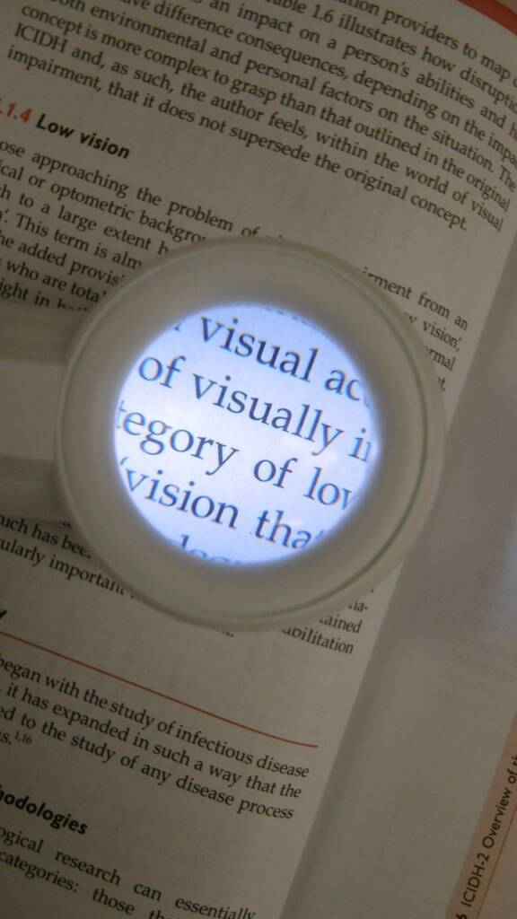 Lit magnifier over a book enlarging the word visually.