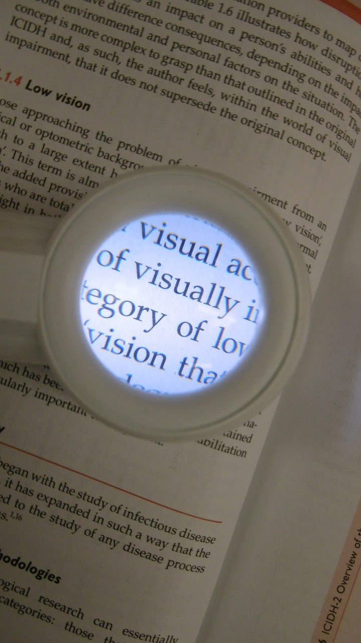 Lit magnifier over a book enlarging the word visually.