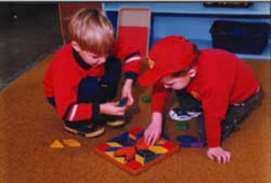 Two boys playing with blocks on the floor