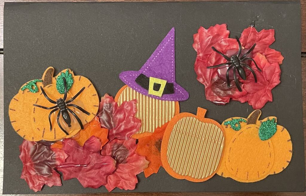 Halloween craft with textured pumpkins, a leaf, and spiders