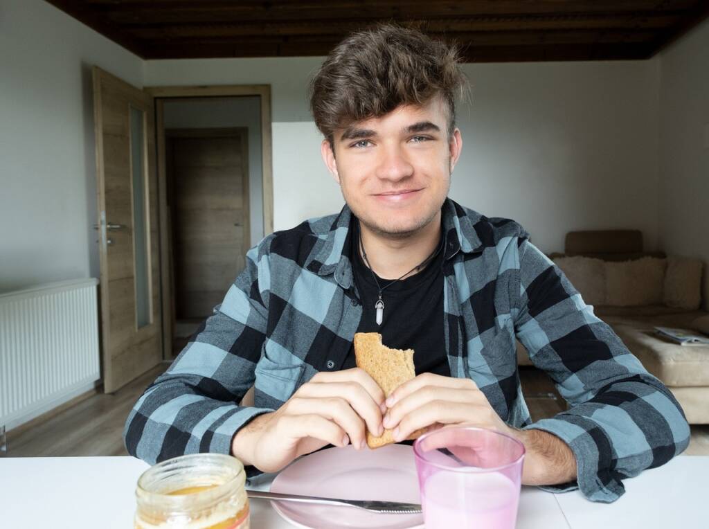 Young man eating breakfast alone in his apartment.