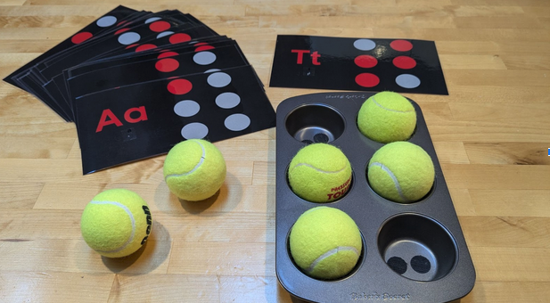 Braille letter cards and a muffin tin to make the braille cell letters