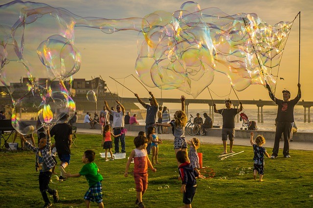 Children in the park with playing with giant bubble