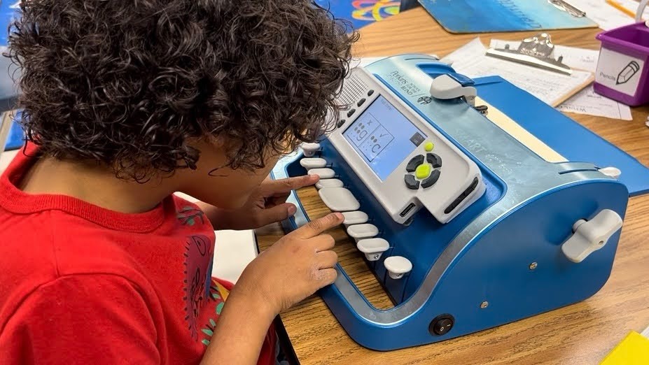 Student using an electronic braille machine.